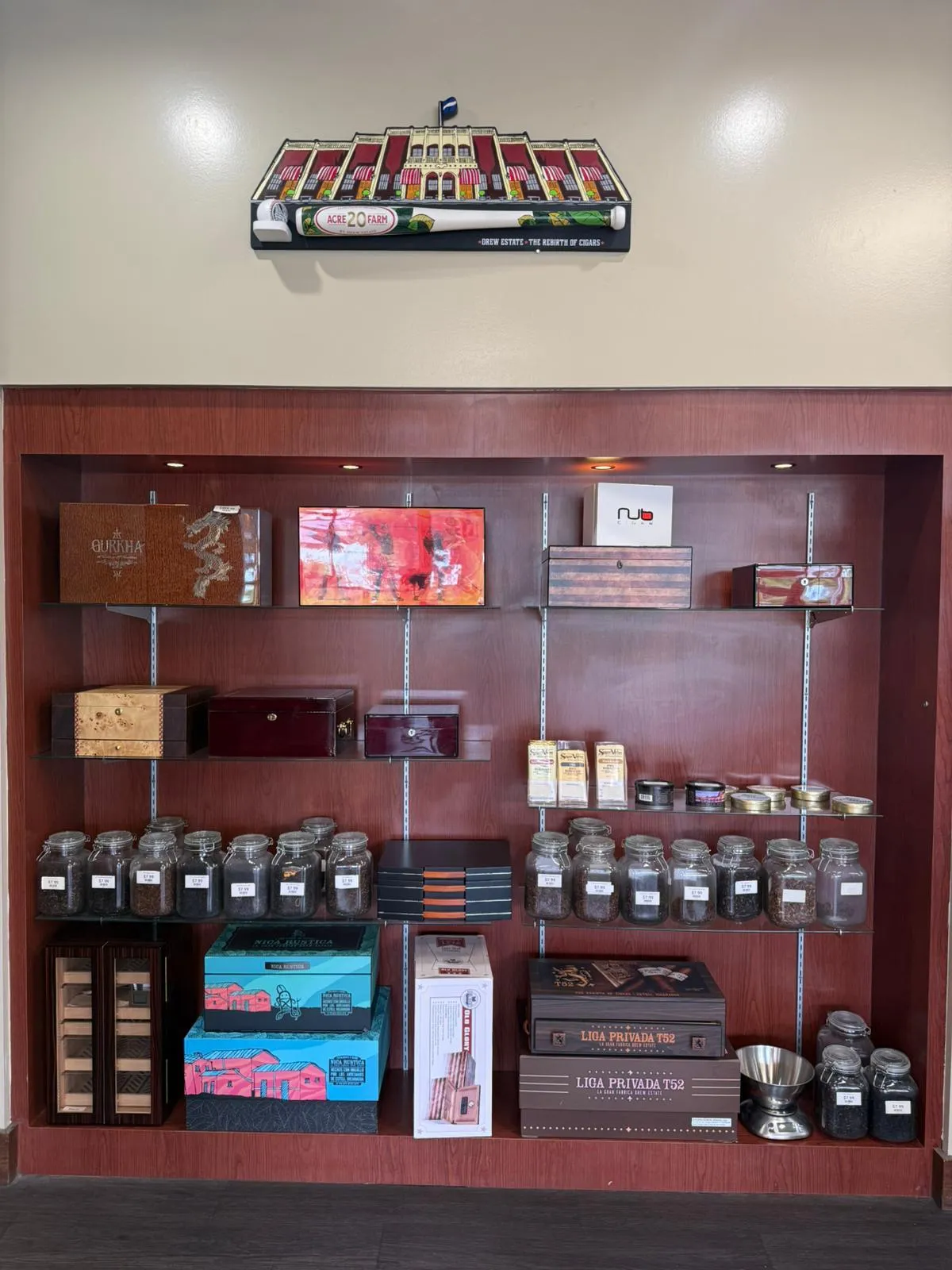 Boutique brand display at Cigar Heaven — Drew Estate ACID 20 Farm, Gurkha, Liga Privada T52, Nub, and a wall of cigar boxes and humidor accessories.